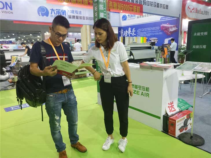 萨震美女销售在展会上为参观者讲解节能空压机